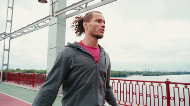 Focused sportsman rope jumping on bridge with nature landscape on background - Metraje, vídeo