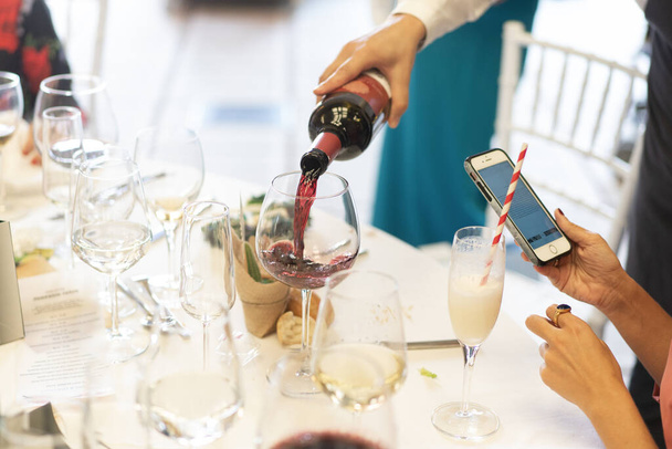 Kellner serviert ein Glas Wein bei einem Bankett - Foto, Bild