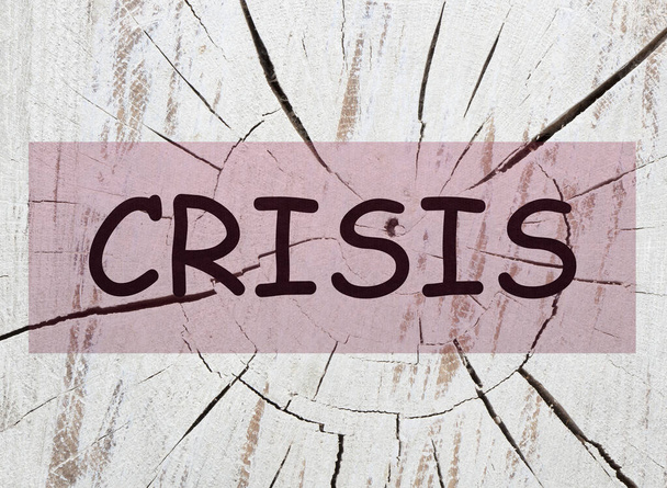 The word crisis over cracked wood background - Zdjęcie, obraz