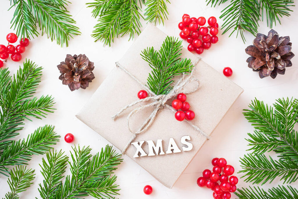 Natal eco flat lay: presentes embrulhados em papel artesanal, ramos de abeto e bagas vermelhas como decoração. Conceito de sustentabilidade. - Foto, Imagem