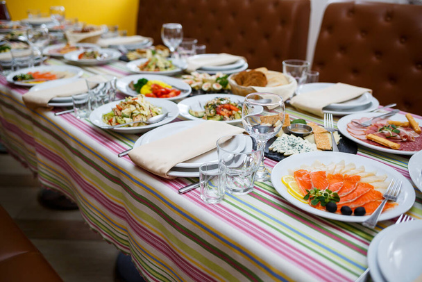 Mesa no restaurante, pratos em pratos brancos, banquete festivo - Foto, Imagem
