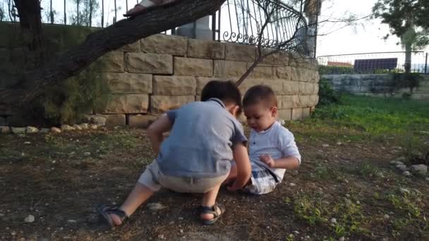 Adorable 4 years old checking on and kissing his injured knee after he felt down. Siblings taking care of each other - Footage, Video