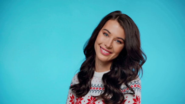 Positieve jonge volwassen vrouw poseren en glimlachen, terwijl kijken naar de camera op blauw - Video