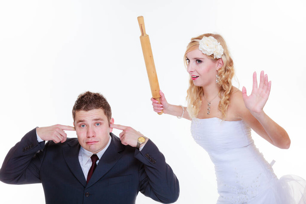 Relationship problems and troubles concept. Groom and bride having quarrel argument, woman holding rolling pin - Foto, Bild