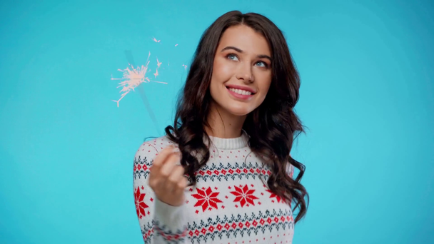 Smiling woman dancing while holding sparkler on blue - Footage, Video