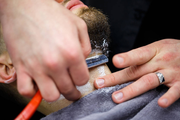 Couper une barbe dans un salon de coiffure à un homme - Photo, image