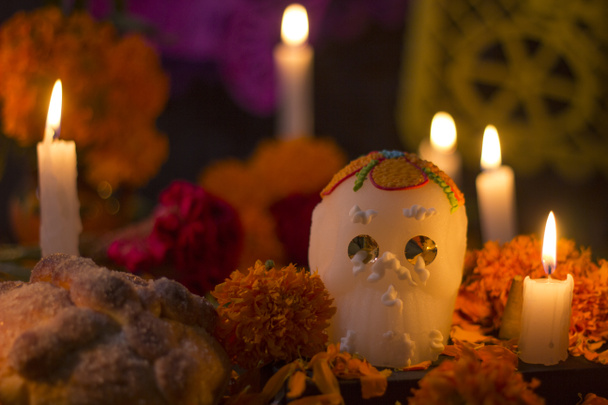 Сахарный череп со свечами, хлебом и цветами украшения на день умершего алтаря мексиканской традиции - Фото, изображение
