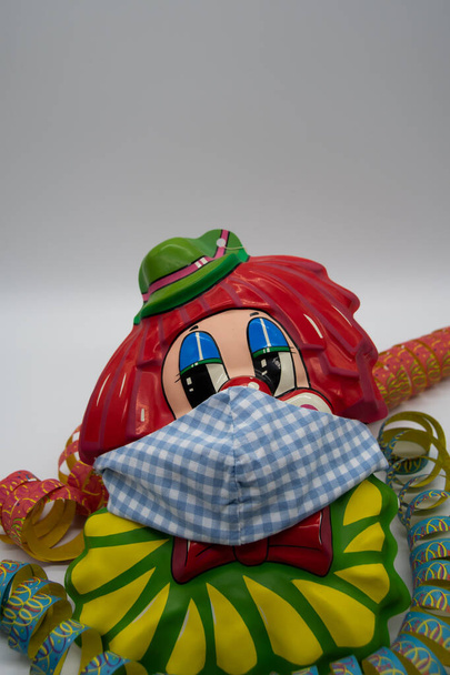 Un clown portant un masque protecteur avec quelques frappes aériennes colorées.Il n'y aura pas de carnaval en Allemagne cette année à cause du virus de la couronne - Photo, image