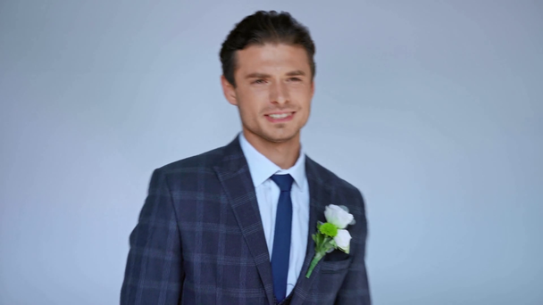 stylish groom looking at camera and dancing isolated on grey - Video