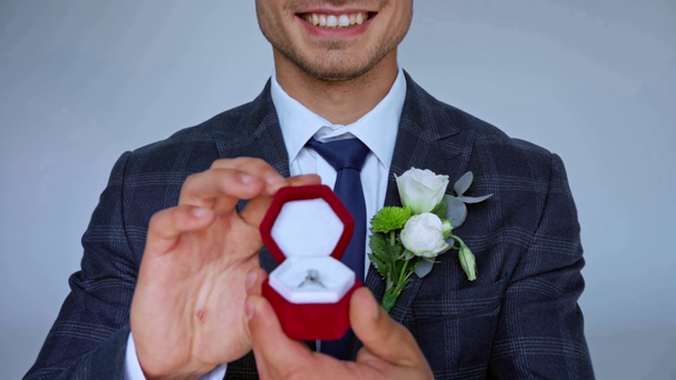 foco de rack de hombre haciendo propuesta y caja de sujeción con anillo aislado en gris - Imágenes, Vídeo