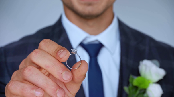 focus pull dell'uomo che fa proposta e tiene l'anello d'argento isolato sul grigio - Filmati, video