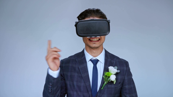 allegro sposo in realtà virtuale auricolare gesticolare isolato su grigio - Filmati, video
