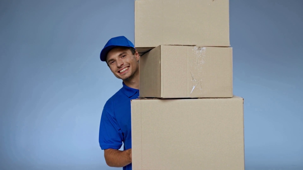 homem de entrega feliz na tampa segurando caixas de papelão no cinza - Filmagem, Vídeo