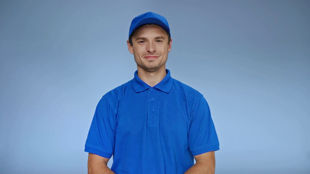 delivery man in cap χαμογελώντας και δίνοντας κουτί στον πελάτη σε γκρι - Πλάνα, βίντεο