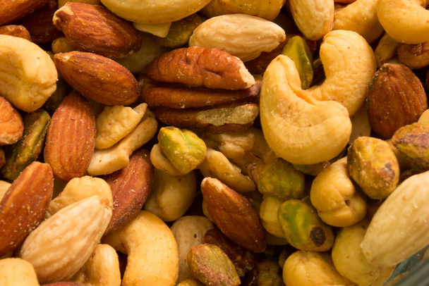 This is a photograph of mixed nuts including Cashews,Almonds,Pistachios and Pecans - Photo, Image