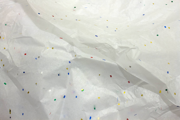 This is a photograph of White tissue wrapping paper with confetti  - Photo, Image