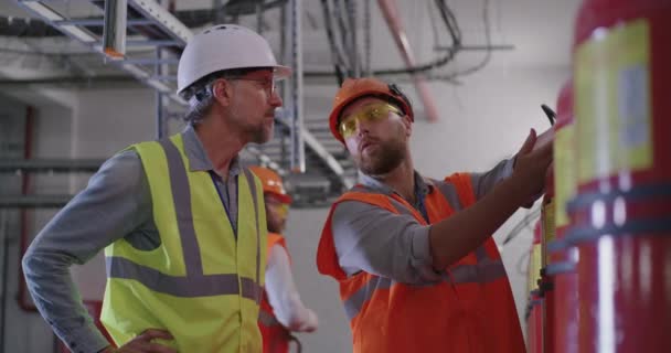 Μηχανικοί που εξετάζουν πυροσβεστήρες σε σταθμό ηλεκτροπαραγωγής - Πλάνα, βίντεο