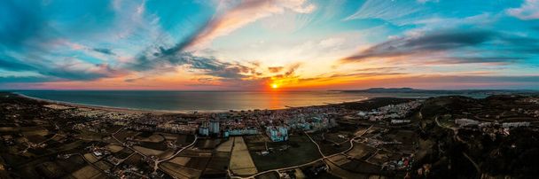 Veduta aerea panoramica della Costa Da Caparica, Portogallo al tramonto. Coastline di spiagge sabbiose gloriose e potenti onde dell'oceano Atlantico. - Foto, immagini