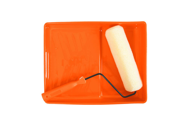 Festékhenger és narancssárga tálca fehér alapon. - Fotó, kép