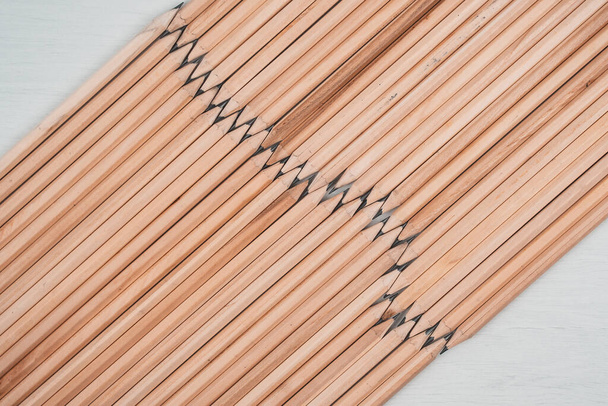 Crayons en bois disposés en zigzag sur fond blanc. - Photo, image