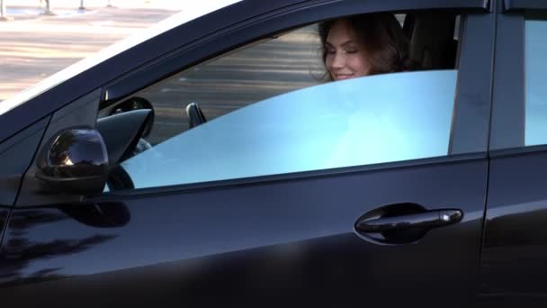 Ευτυχισμένη νεαρή γυναίκα που κάθεται στο αυτοκίνητο. - Πλάνα, βίντεο