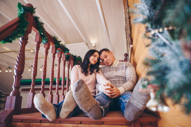 Christmas gift: warm wool socks. A couple in love in warm clothes. Legs close up - Φωτογραφία, εικόνα