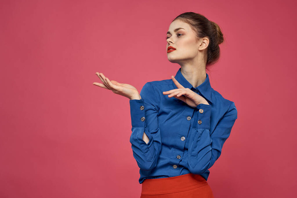mujer de moda en camisa azul sobre fondo rosa Falda roja emociones modelo gesto con las manos recortadas ver Copiar el espacio - Foto, imagen