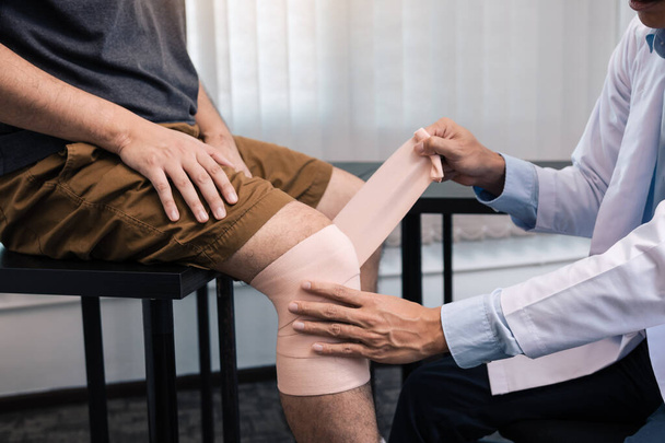 Ασιάτες φυσικοθεραπευτές εξετάζουν τα αποτελέσματα της χειρουργικής επέμβασης στο γόνατο. - Φωτογραφία, εικόνα