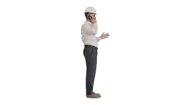 Engineer in white hard hat talking on his mobile phone on white - Fotografie, Obrázek