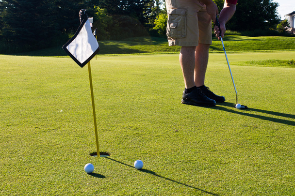Golfista practicando poner pelotas de golf
 - Foto, imagen