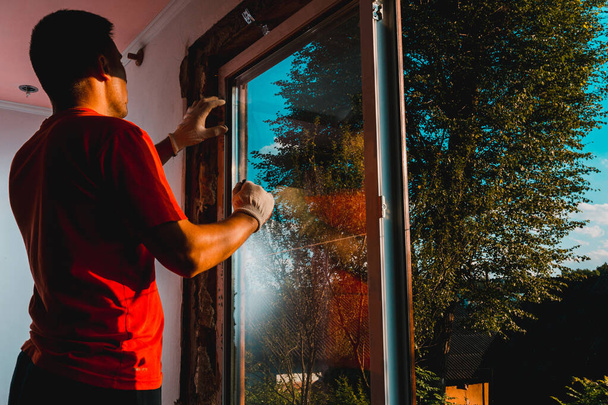 Pracovník vloží sklo do rámu okna, trojité zasklení plastového okna, izolace a izolace.2020 - Fotografie, Obrázek