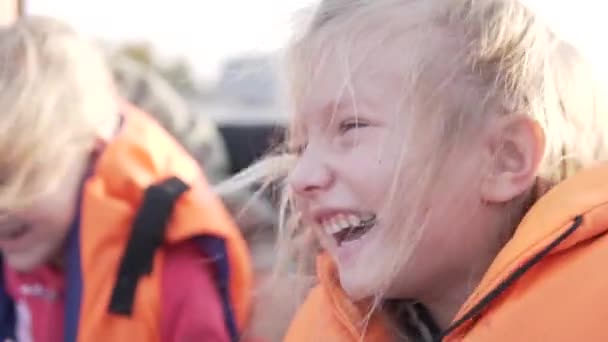 Graciosa niña en un chaleco salvavidas monta en una lancha rápida. - Metraje, vídeo