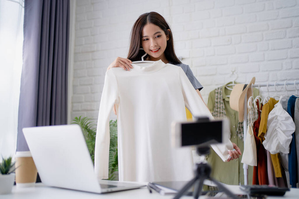 Fiatal ázsiai nő eladó ruhákat online otthon. - Fotó, kép