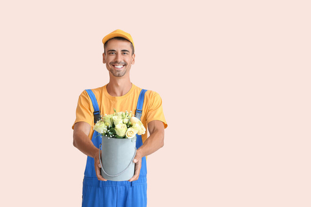 Dostawa człowiek z bukietem kwiatów na tle koloru - Zdjęcie, obraz