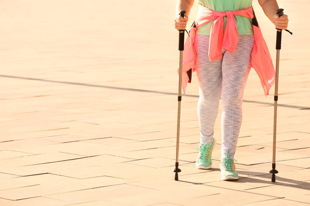 Dojrzała kobieta z biegunami spacerowymi na zewnątrz - Zdjęcie, obraz