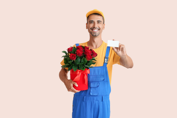 Delivery man with bouquet of flowers and business card on color background - Photo, Image