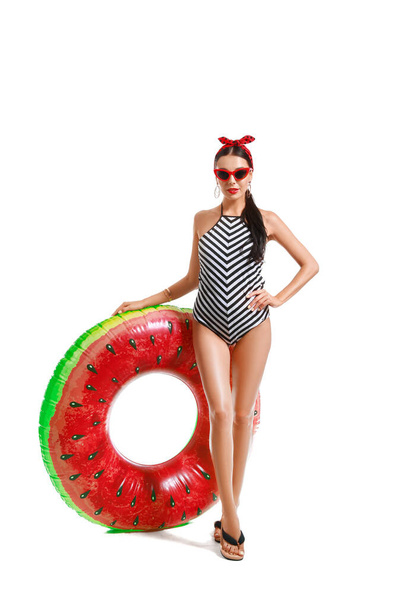 Beautiful young woman in swimming suit and with inflatable ring on white background - Foto, Imagem