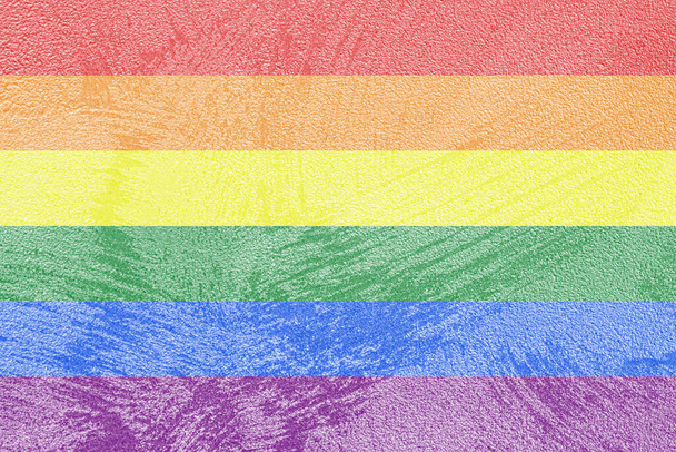 Rainbow LGBTQ oder Gay Pride Flagge auf dekorativem Gips oder Beton. Abstrakter Hintergrund für Design. - Foto, Bild