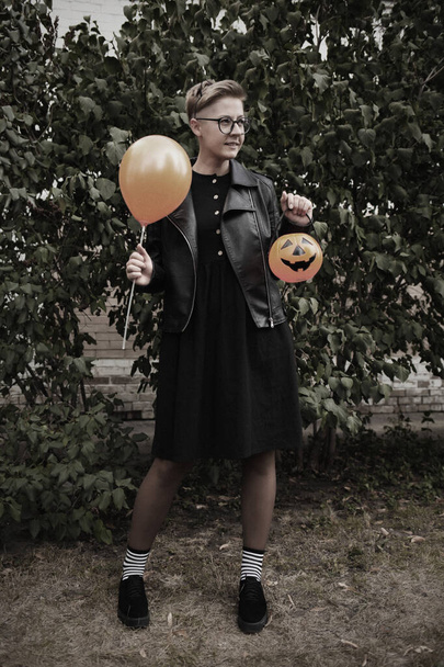 young woman in black hat with a pumpkin - Foto, afbeelding
