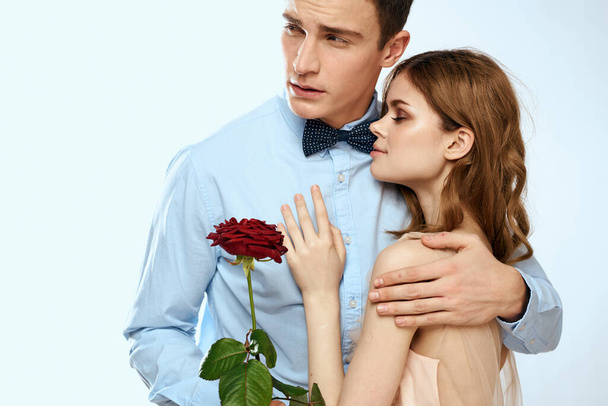 Mies ja nainen punaisella ruusulla kevyellä taustalla rakkaus perheen halauksia - Valokuva, kuva
