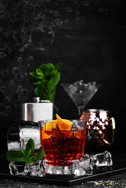 Traditional Negroni cocktail on black stone background. Menu bar. Alcohol. - Fotó, kép