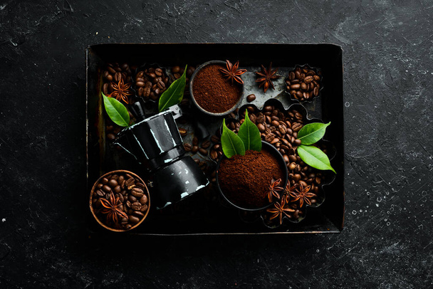Coffee. Roasted fragrant coffee beans and coffee maker on a black stone background. Top view. Free space for your text. - Fotografie, Obrázek