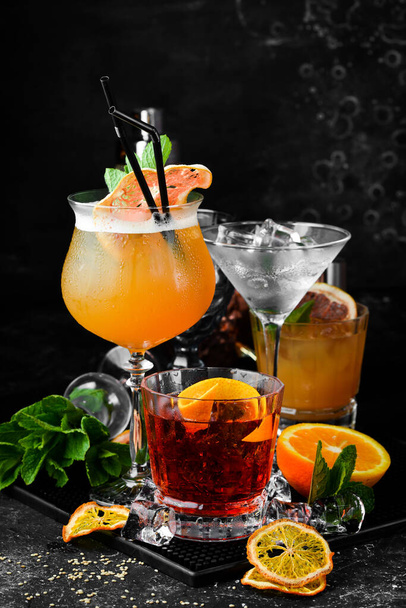 Set van gekleurde alcoholische cocktails op een zwarte stenen achtergrond. Menubalk. Alcohol. - Foto, afbeelding