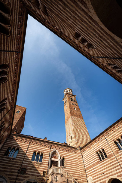 Torre dei Lamberti i Palazzo della Ragione, średniowieczna wieża i pałac w centrum Werony, Piazza delle Erbe, wpisane na listę światowego dziedzictwa UNESCO, Wenecja Euganejska, Włochy, Europa. - Zdjęcie, obraz