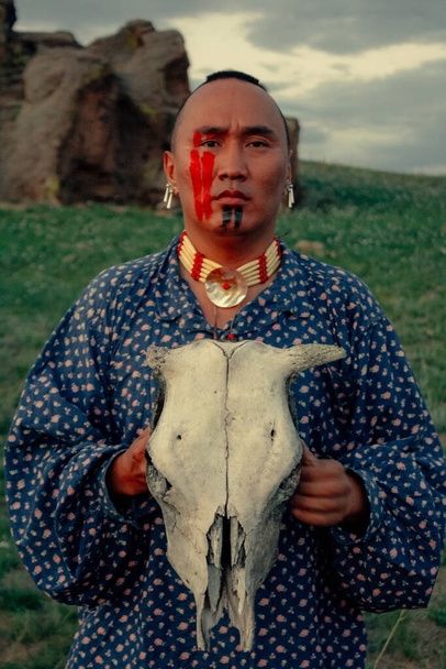 Hombre nativo americano al atardecer al aire libre en la estepa - Foto, Imagen