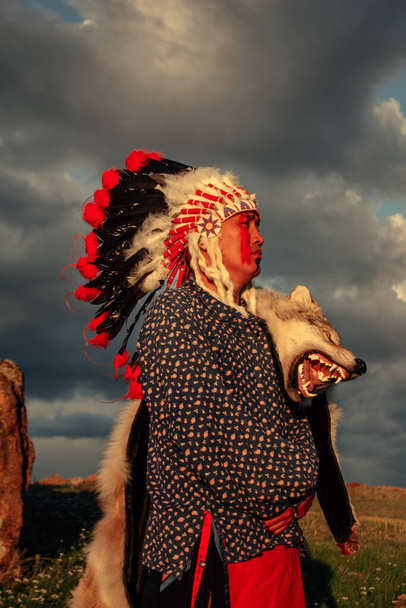 Hombre nativo americano al atardecer al aire libre en la estepa - Foto, imagen