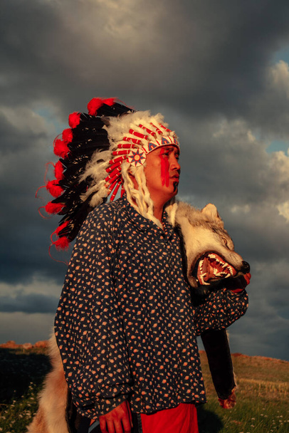 Inheemse Amerikaanse man bij zonsondergang buiten in de steppe - Foto, afbeelding