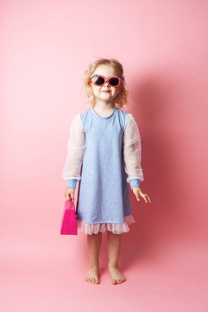 Little girl child in sunglasses with a pink redicle. - Fotografie, Obrázek
