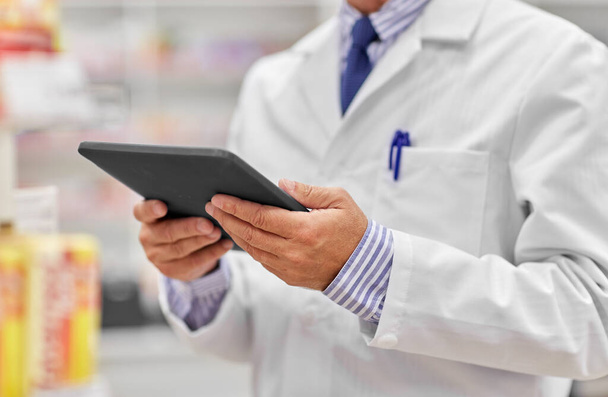 close up of senior pharmacist with tablet pc - 写真・画像