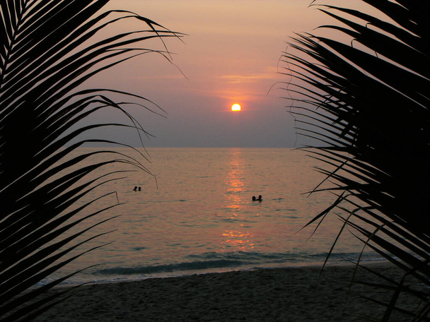 Dwie zakochane pary kąpią się o zachodzie słońca na Samotnej plaży, na wyspie Koh Chang. Tajlandia - Zdjęcie, obraz